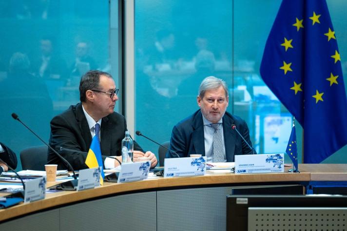 Ville Itälä Director-General of OLAF and Commissioner Johannes Hahn speaking at the roundtable with an EU flag in the background
