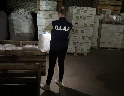 OLAF investigator looking at bags an boxes of pesticides