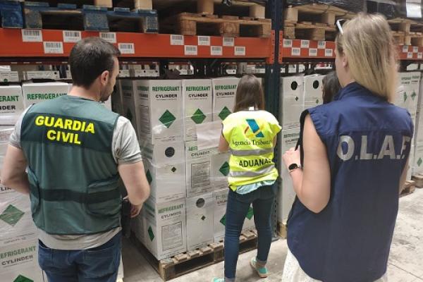 Customs and OLAF officials opening boxes of gas cylinders