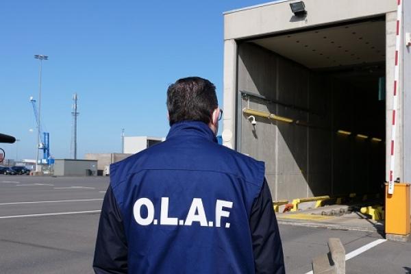 Man wearing an OLAF vest looking at container